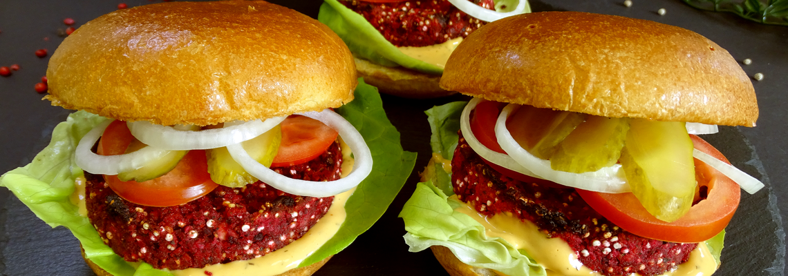 Vegane Burger mit Quinoa Rote-Bete Patty, belegt mit Tomaten, Zwiebeln, Gurken, Salat und Käse